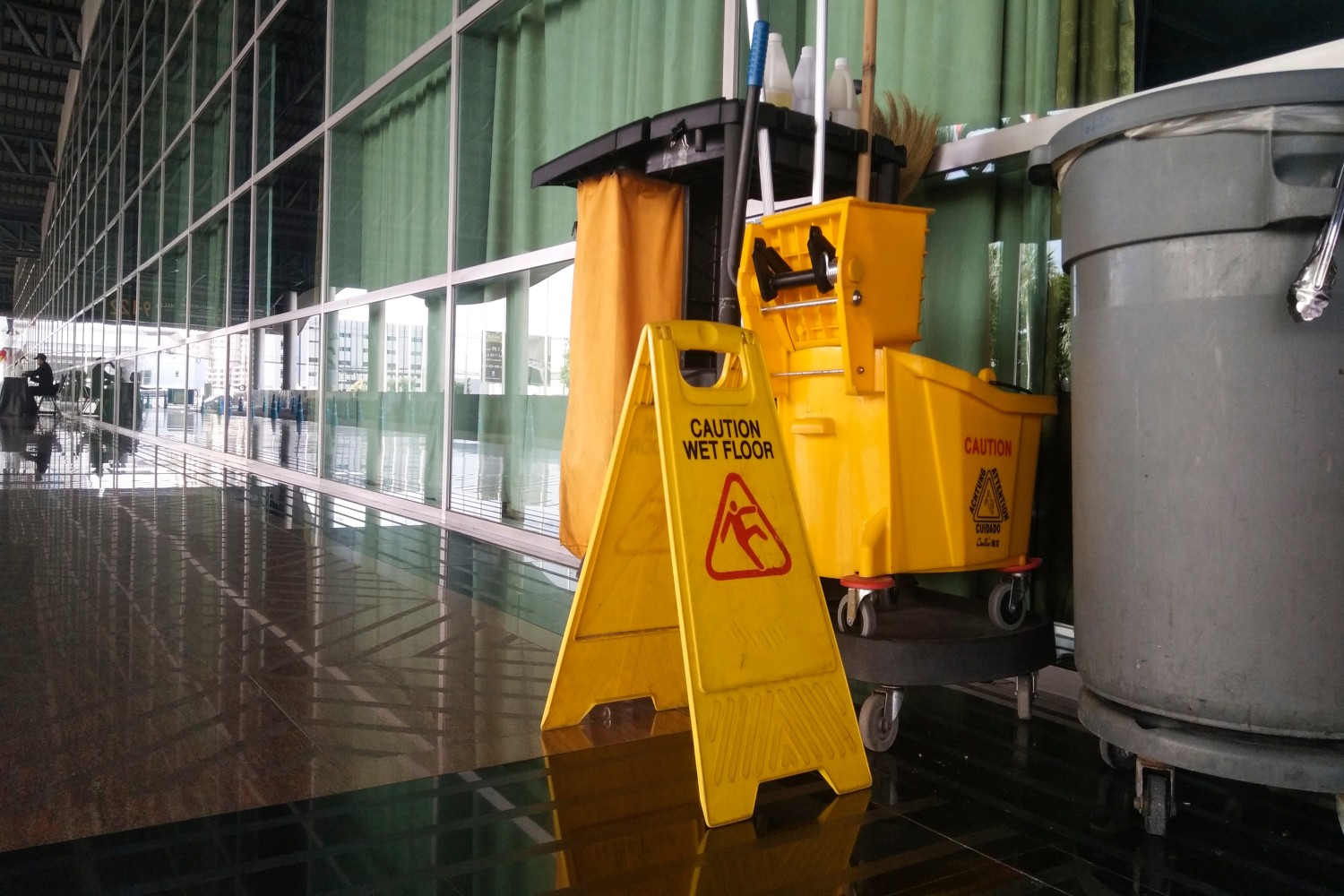 the warning signs cleaning and caution wet floor in the building and janitorial service car